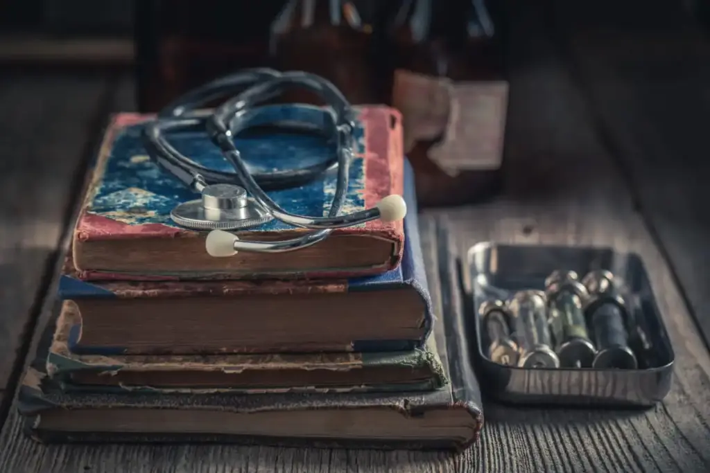 Estestoscópio, seringas e livros médicos antigos