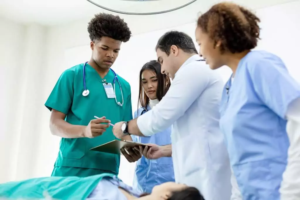 médico e estudantes aplicando tratamento em paciente